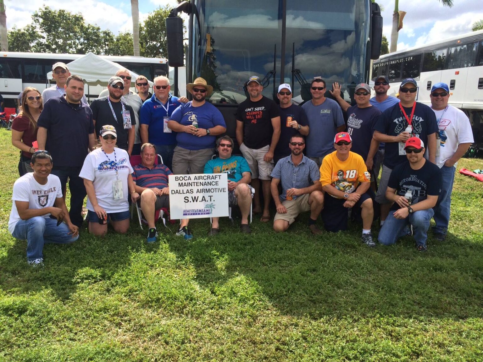 Group of Boca Aircraft Maintenance mechanics and workers in front of a tour bus.